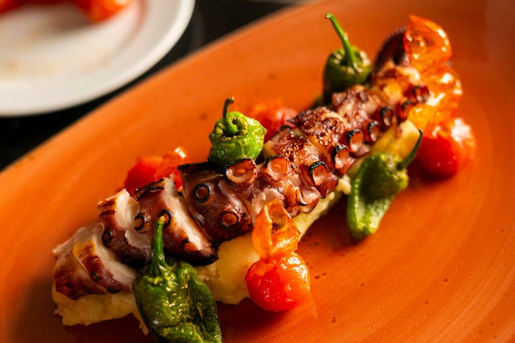 Brazo de pulpo con pimientos verdes y tomate
